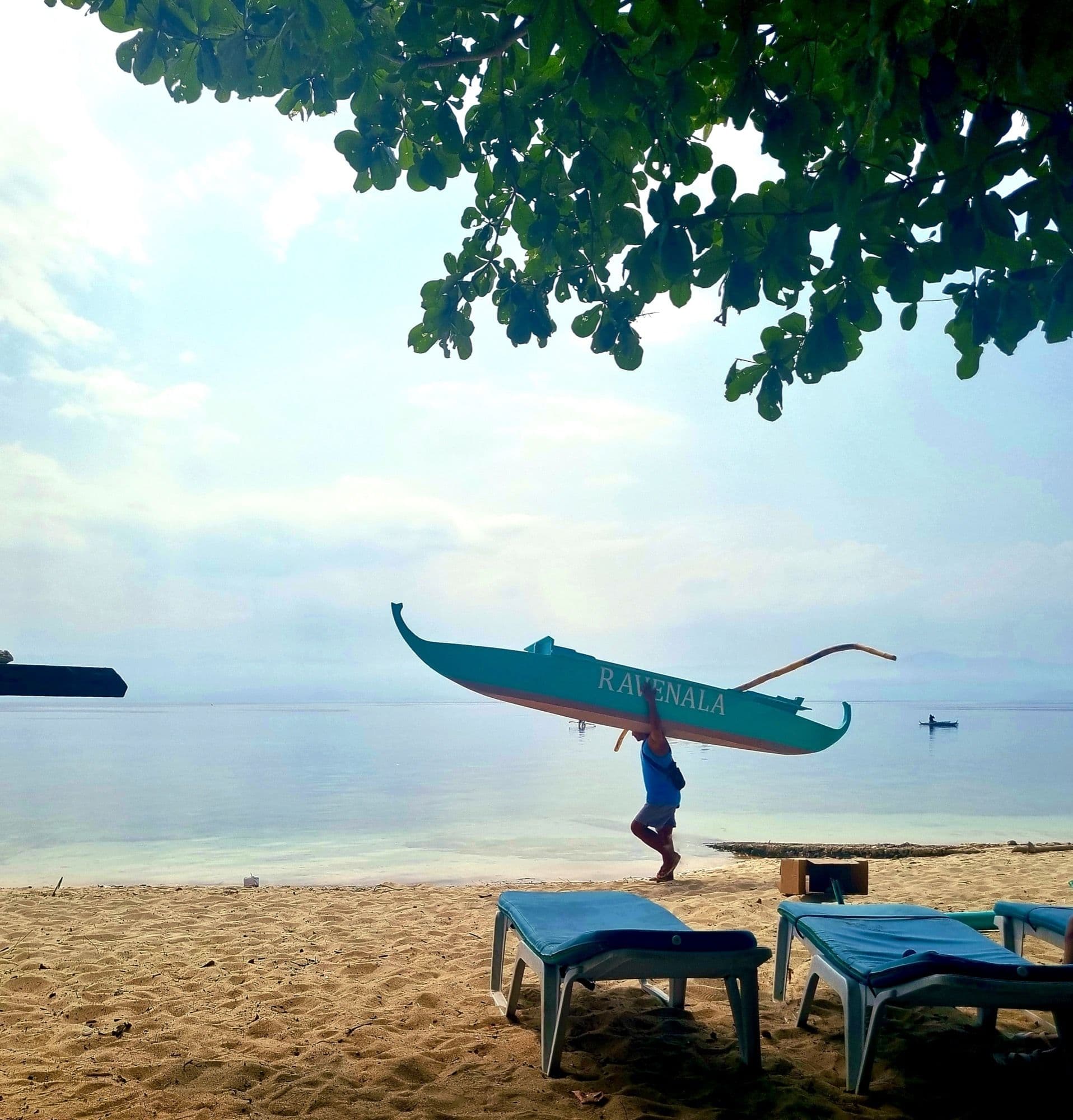 Sun loungers and a banca boat on the shoreline