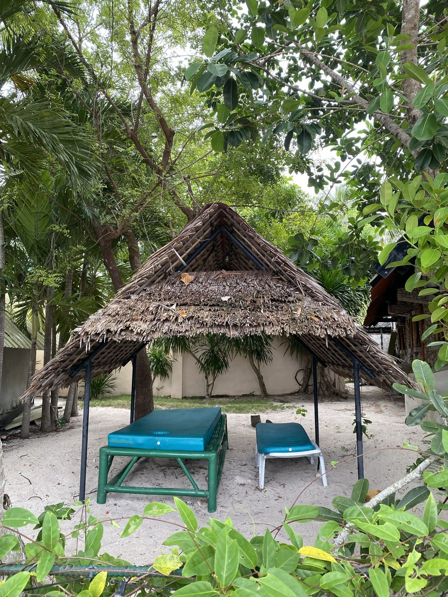 A nipa hut and sun loungers looking out to the water